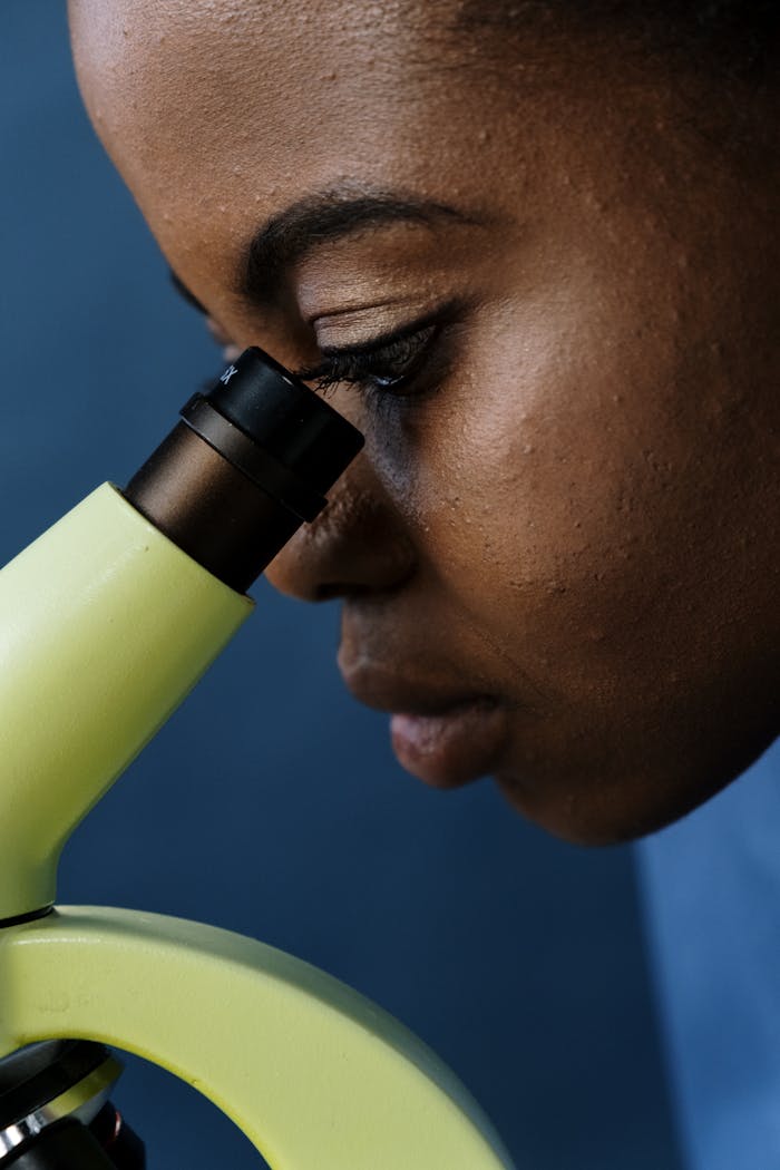 Close-up of a scientist using a microscope for detailed observation in a laboratory setting.